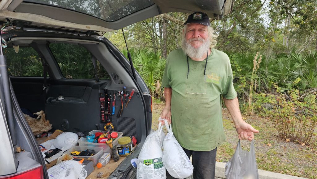 man holding turkeys and ham 