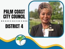 A campaign poster features a person with short, highlighted hair and wearing a suit The text reads "Palm Coast City Council, District " The poster includes a logo with a stylized palm tree and wave design