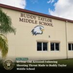 The exterior of Buddy Taylor Middle School with a large eagle logo is shown A news release at the bottom states, “ Year Old Arrested Following Shooting Threat Made to Buddy Taylor Middle School,” accompanied by the Flagler County Sheriff's Office emblem