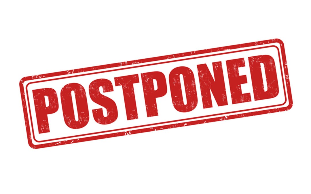 A red, rectangular stamp with the word "POSTPONED" in bold, capital letters The text is slightly distressed, giving it a worn look, and is set against a white background