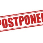 A red, rectangular stamp with the word "POSTPONED" in bold, capital letters The text is slightly distressed, giving it a worn look, and is set against a white background