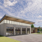 A modern fire station building with large glass windows and a flat roof The sign reads "Palm Coast Fire Department " Surrounding the building are green trees and a partly cloudy sky