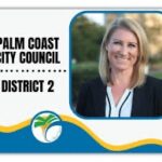 Portrait of a smiling person with shoulder length blonde hair, wearing a black blazer and white shirt The text reads "Palm Coast City Council, District " with a city logo featuring a palm tree