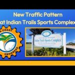 Image shows a sign for the City of Palm Coast's Indian Trails Sports Complex under a blue sky The Palm Coast Progress logo is on the left Text above reads: "New Traffic Pattern at Indian Trails Sports Complex