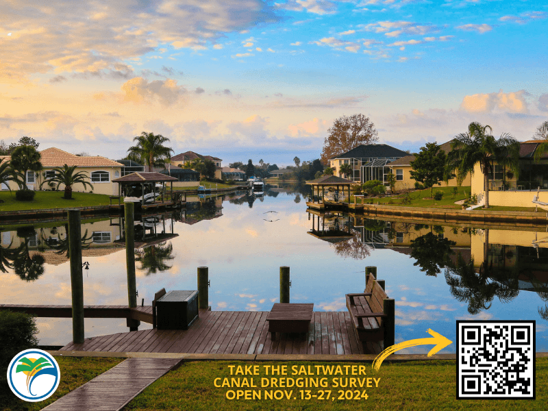 A scenic view of a calm canal surrounded by houses, palm trees, and docks at sunset A yellow banner reads, "Take the Saltwater Canal Dredging Survey, Open Nov , ," with a QR code and logo in the corner