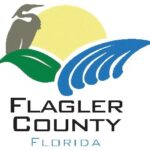 Flagler County logo featuring a stylized sun, a bird silhouette, green land, blue waves, and the text "Flagler County Florida